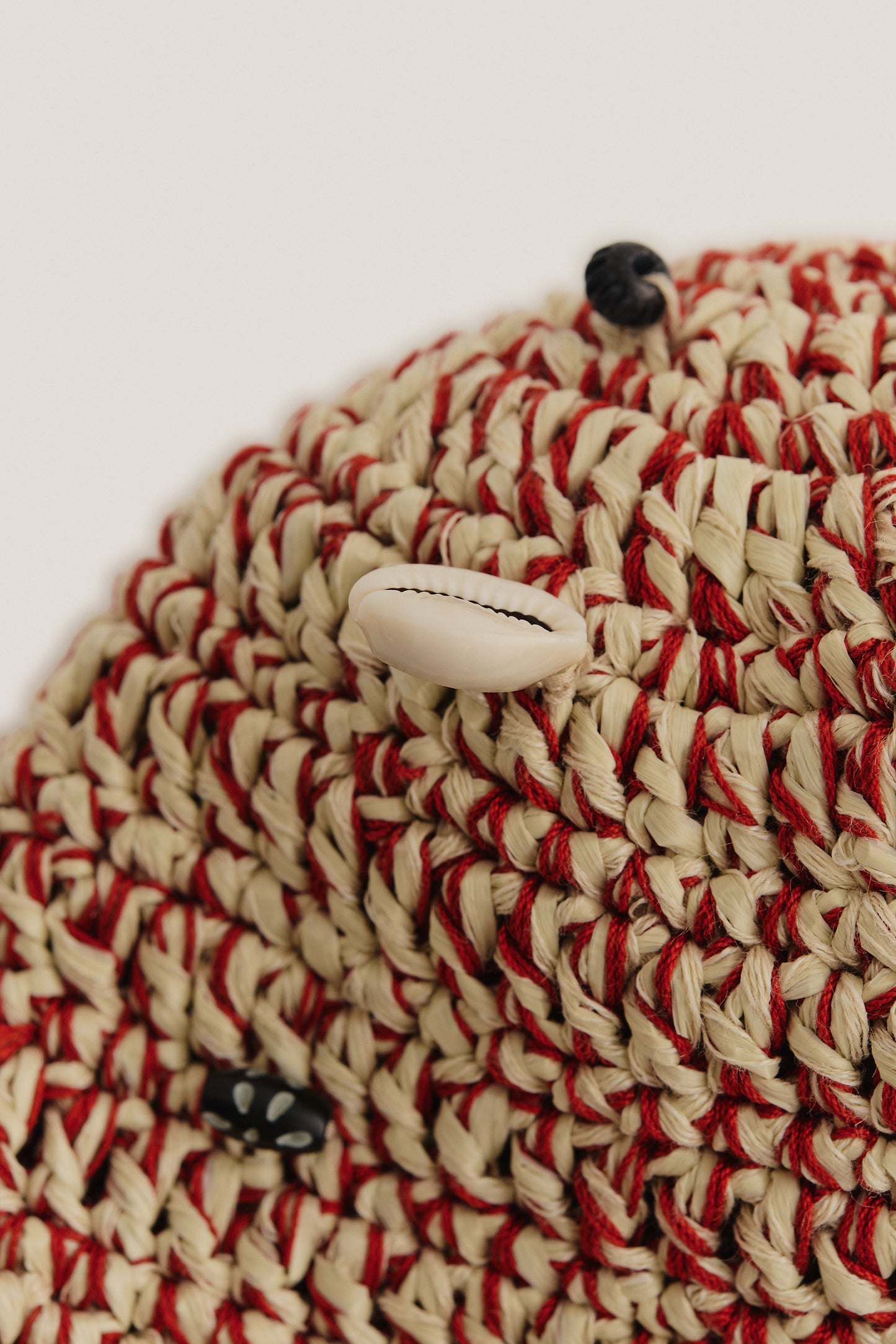 Women's accessories bucket hat, crocheted raffia-like viscose-linen blend, red and natural with shells and black wooden beads.
