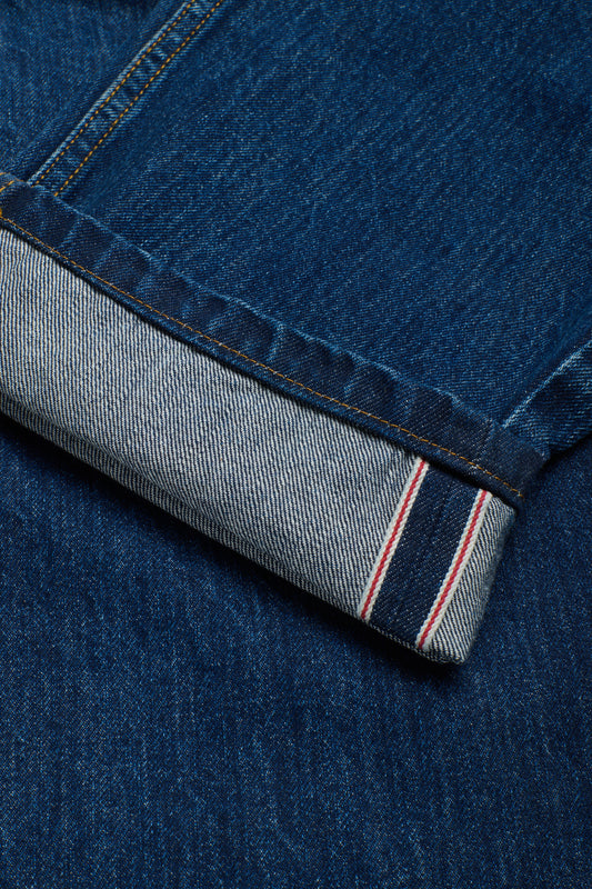 Unisex long-pants, 100% organic cotton, enzyme washed denim blue jeans with selvedge cuff.