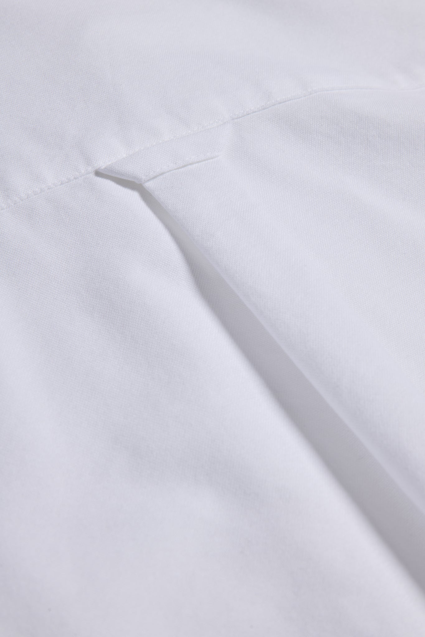 Unisex long-sleeved shirt, white organic cotton, with a visible pocket detail.