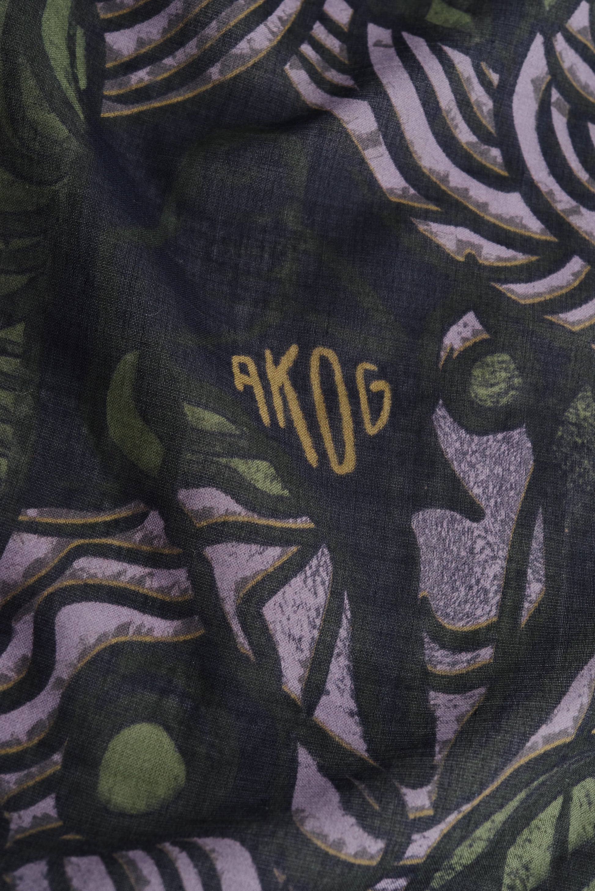Unisex accessories bandana, 100% cotton, dark green with African wildlife print and "AKOG" logo.