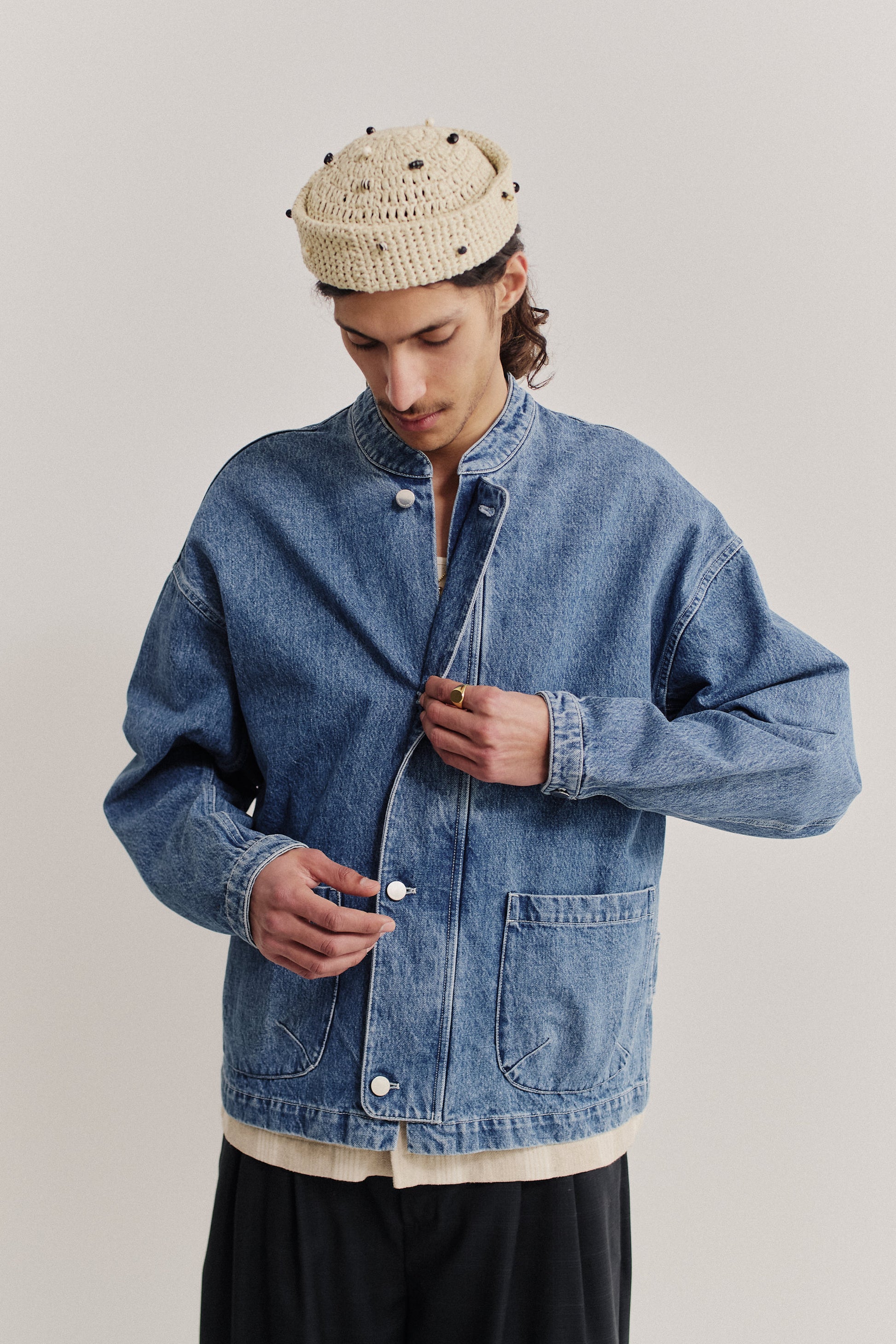 Men's outerwear denim jacket, stone washed indigo, with stand-up collar, patch pockets, and buttoned cuffs.
