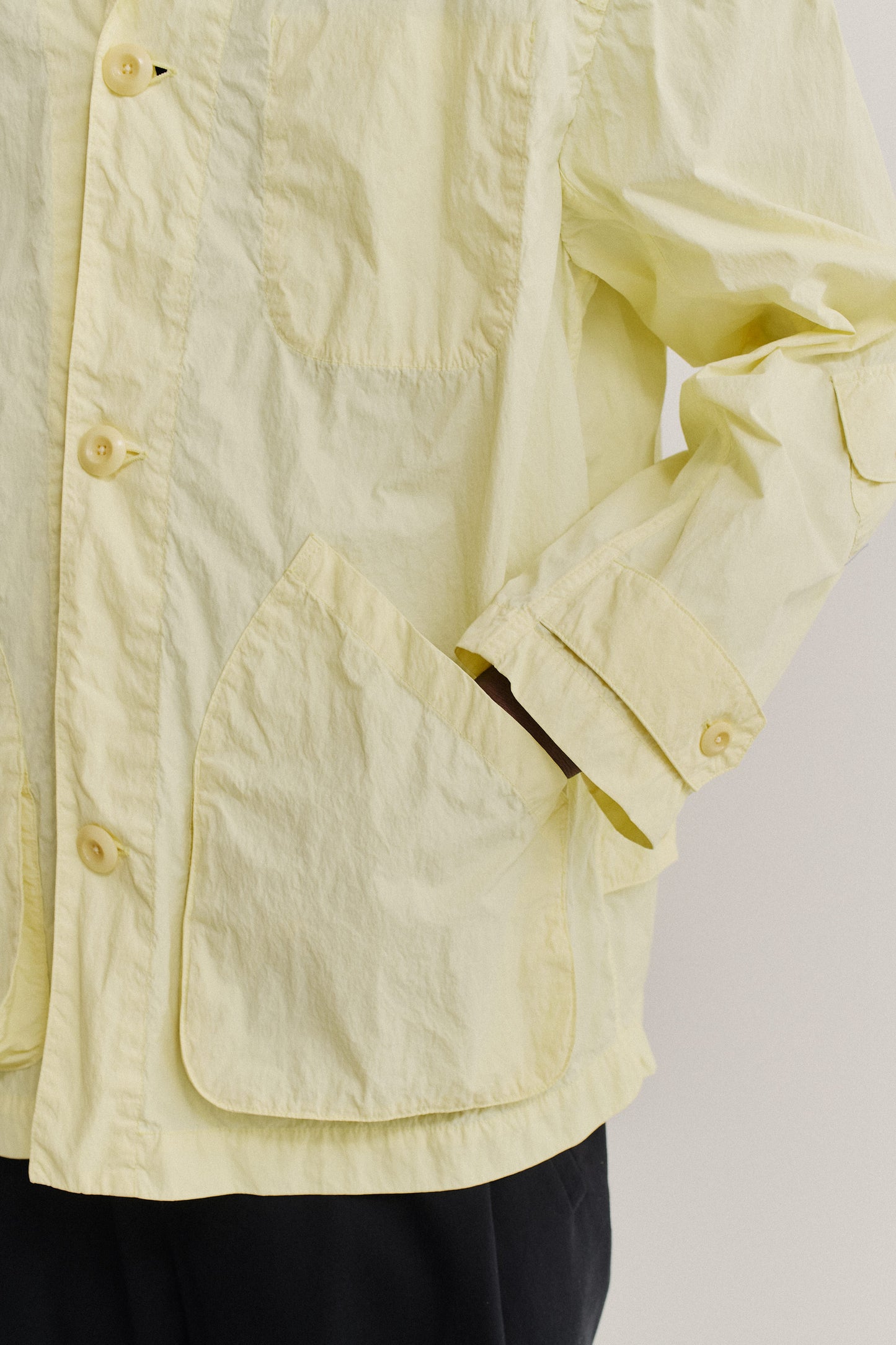Men's outerwear jacket, recycled polyamide, garment-dyed washed light yellow, with patch pockets and corozo buttons.