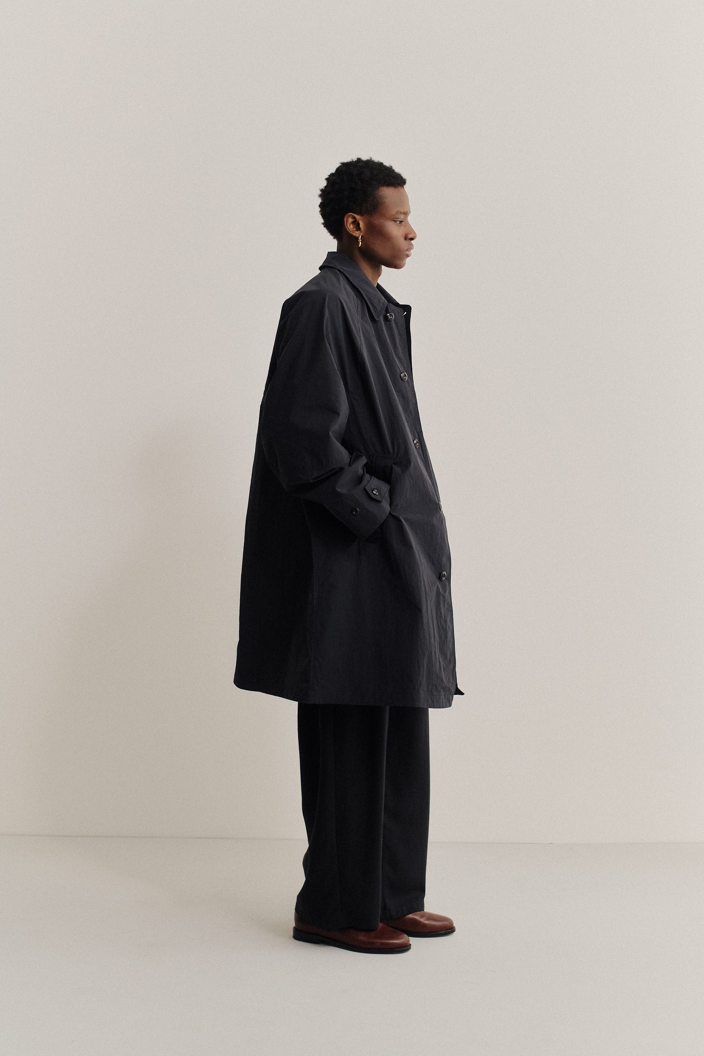 Men's outerwear, oversized black recycled nylon and cotton blend Serrara Mac with reverse collar.