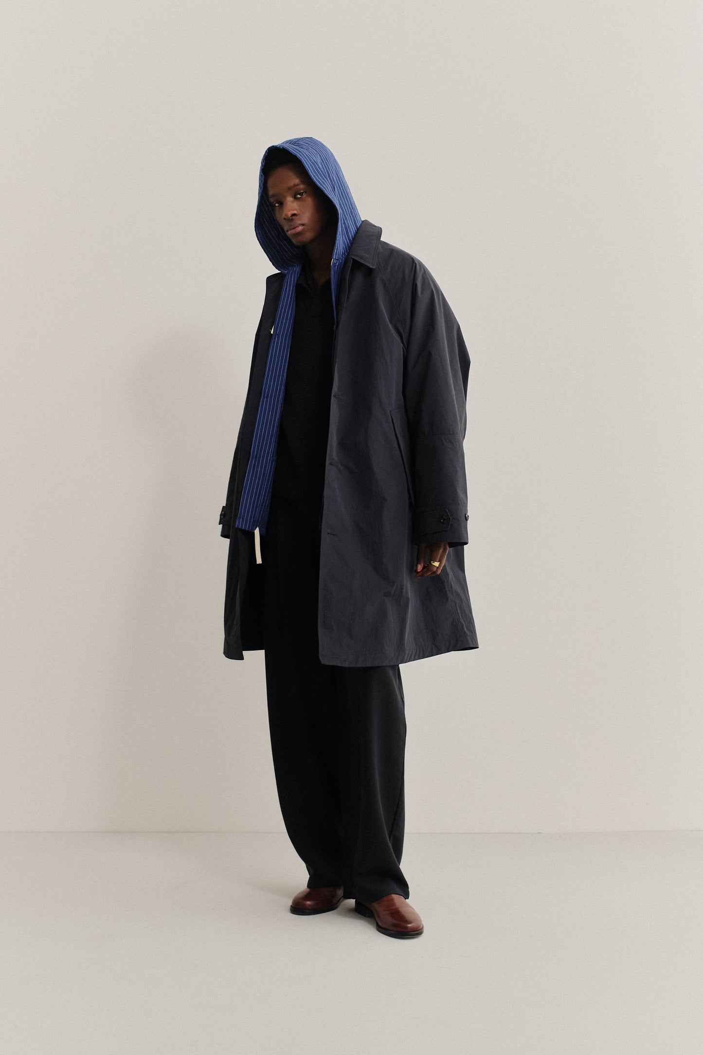Men's outerwear, oversized navy recycled nylon-cotton blend Serrara Mac with blue striped hood.