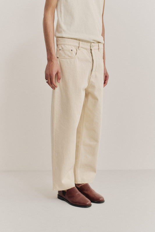 Men's long-pants, organic cotton raw denim, pre-washed off-white, loose fit, tapered leg, cropped length.
