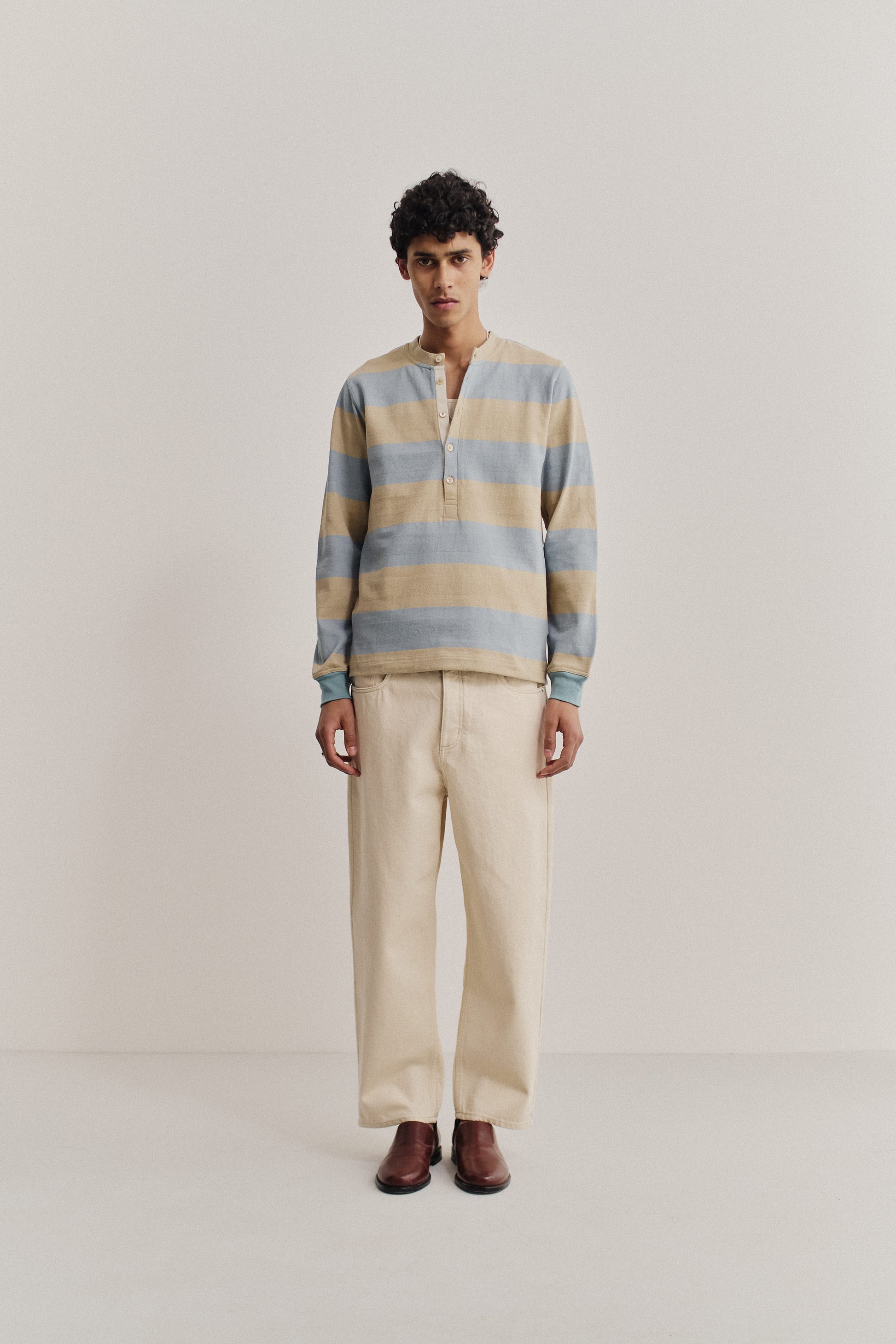 Men's long-pants, organic cotton raw denim, off-white, loose fit, tapered leg, cropped length.