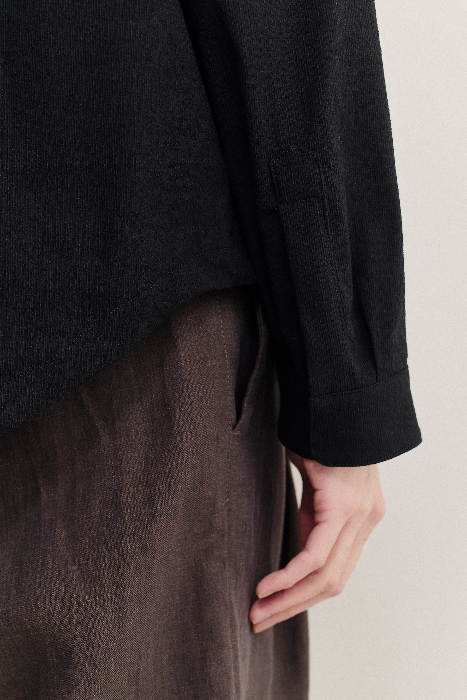 Men's long-sleeved shirt, black cotton blend with irregular wavy stripes, dropped shoulder, and adjustable cuffs.