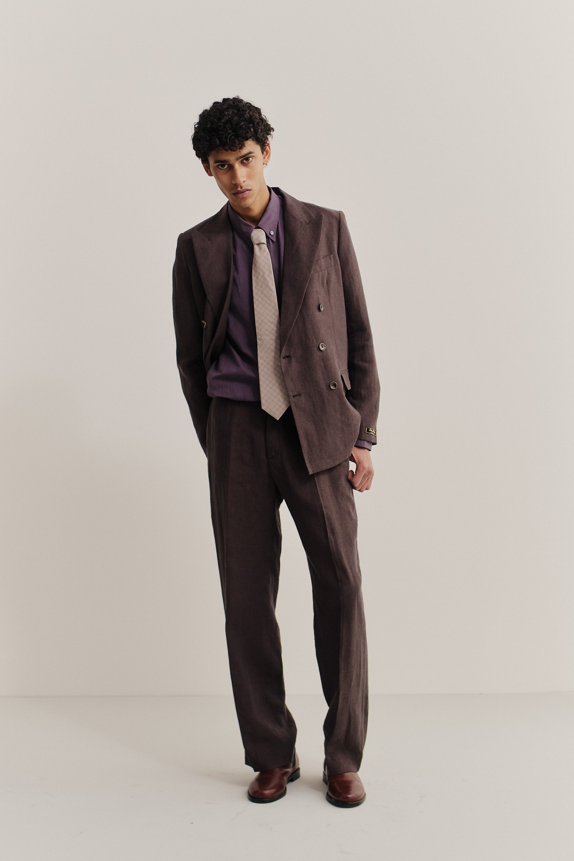 Men's tailoring, long-pants, and long-sleeved shirt, cotton, brown suit with purple shirt and beige tie.