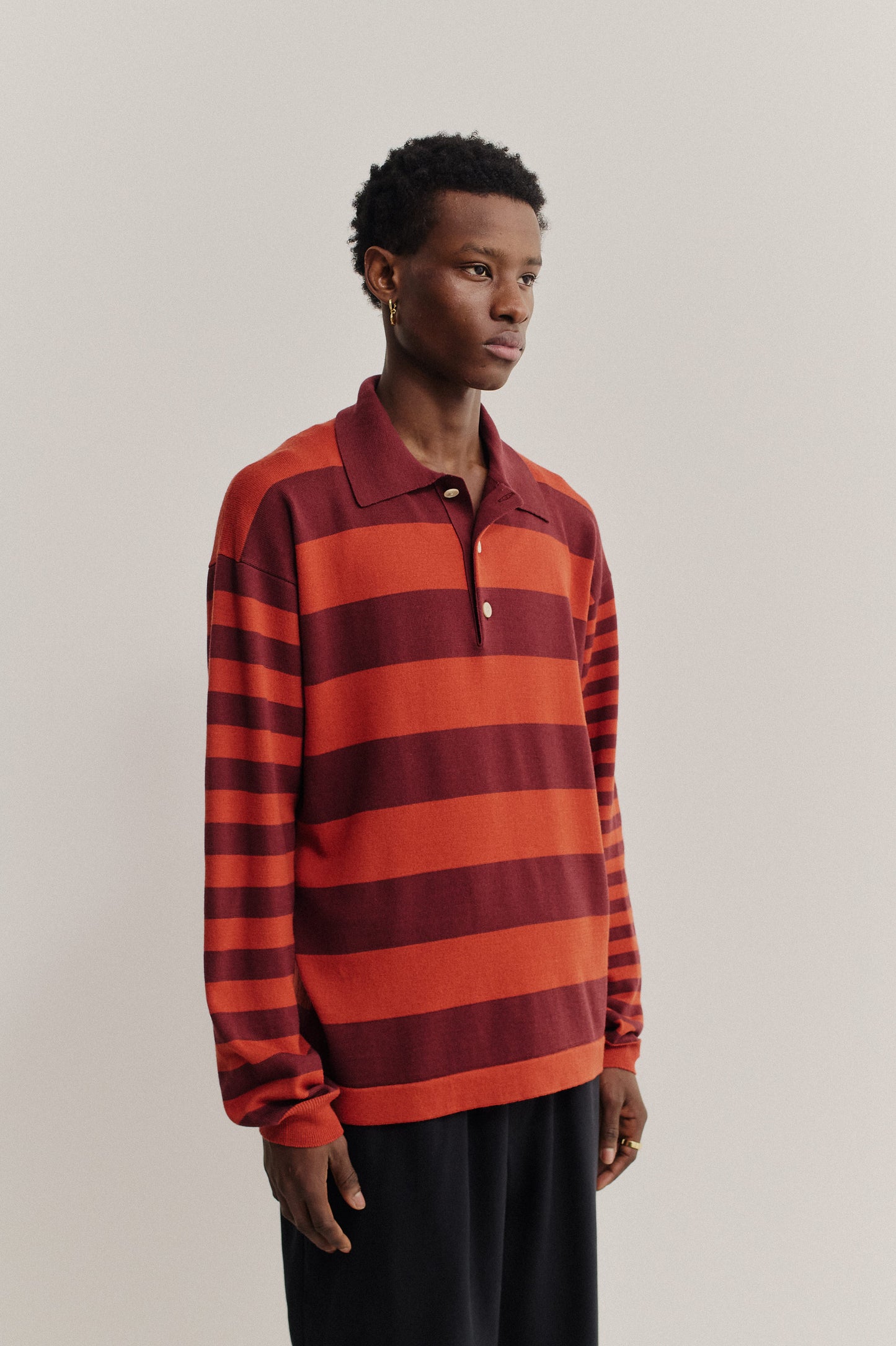 Men's knit long-sleeved polo shirt, 100% fine merino wool, red and burgundy horizontal stripes.
