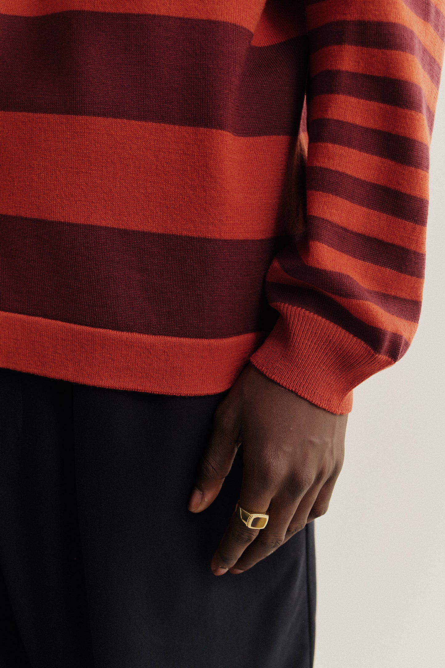 Men's knit, long-sleeved polo shirt, 100% fine merino wool, striped in red and burgundy.