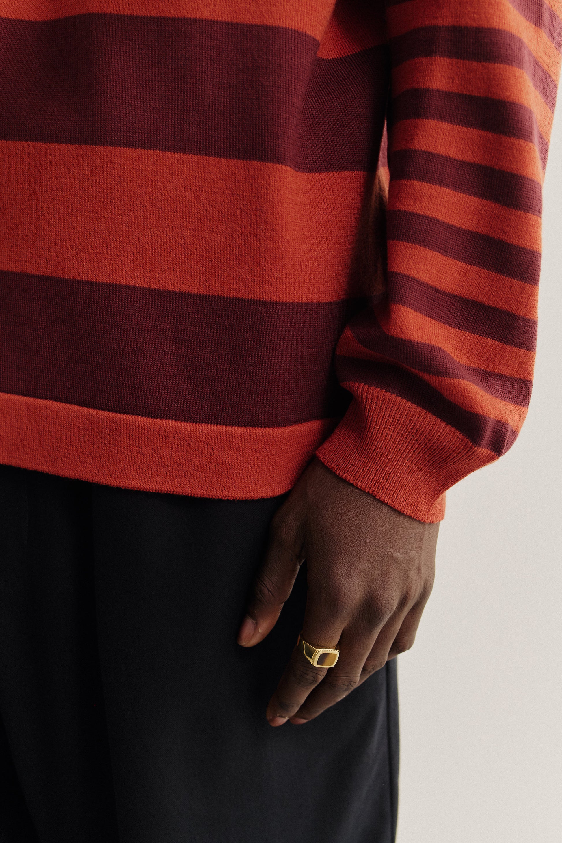 Men's knit, long-sleeved polo shirt, 100% fine merino wool, striped in red and burgundy.