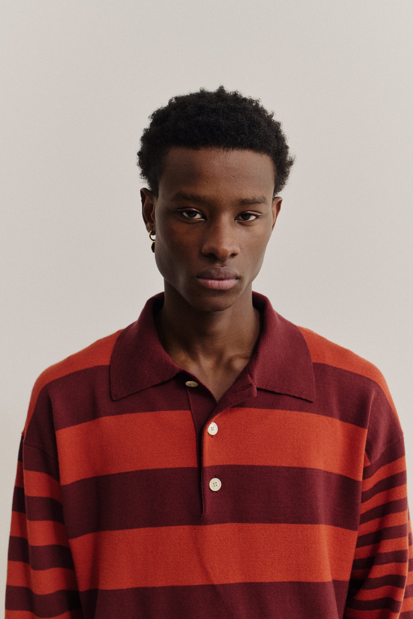 Men's knit short-sleeved polo shirt, 100% fine merino wool, striped in red and maroon.