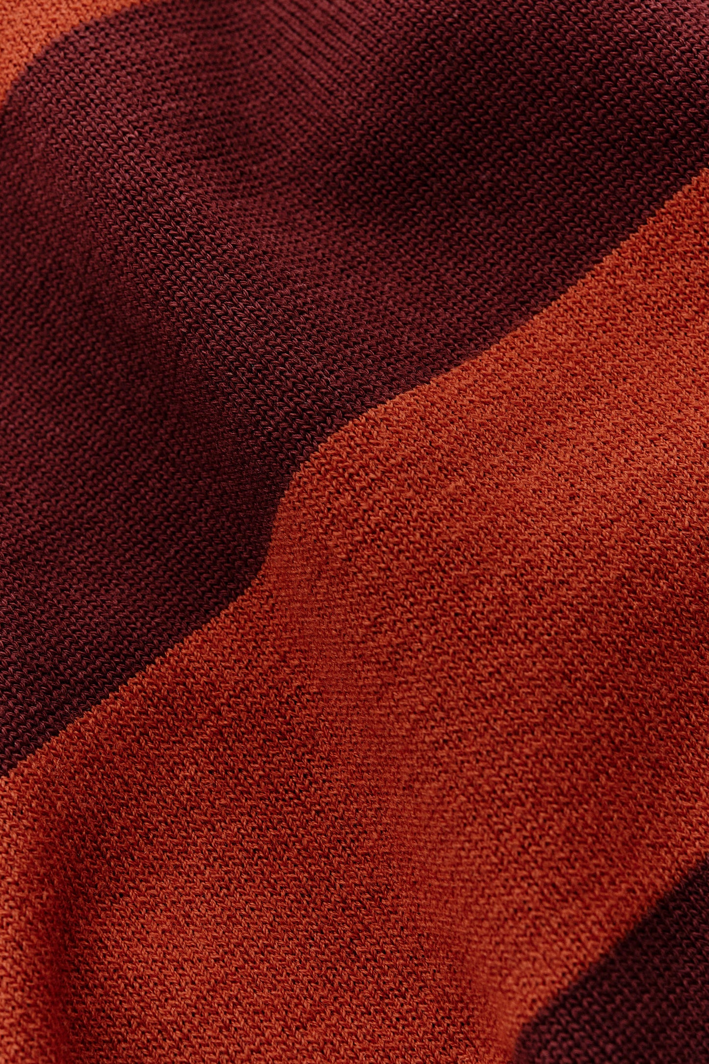 Men's knit short-sleeved polo shirt, 100% fine merino wool, striped in dark brown and burnt orange.