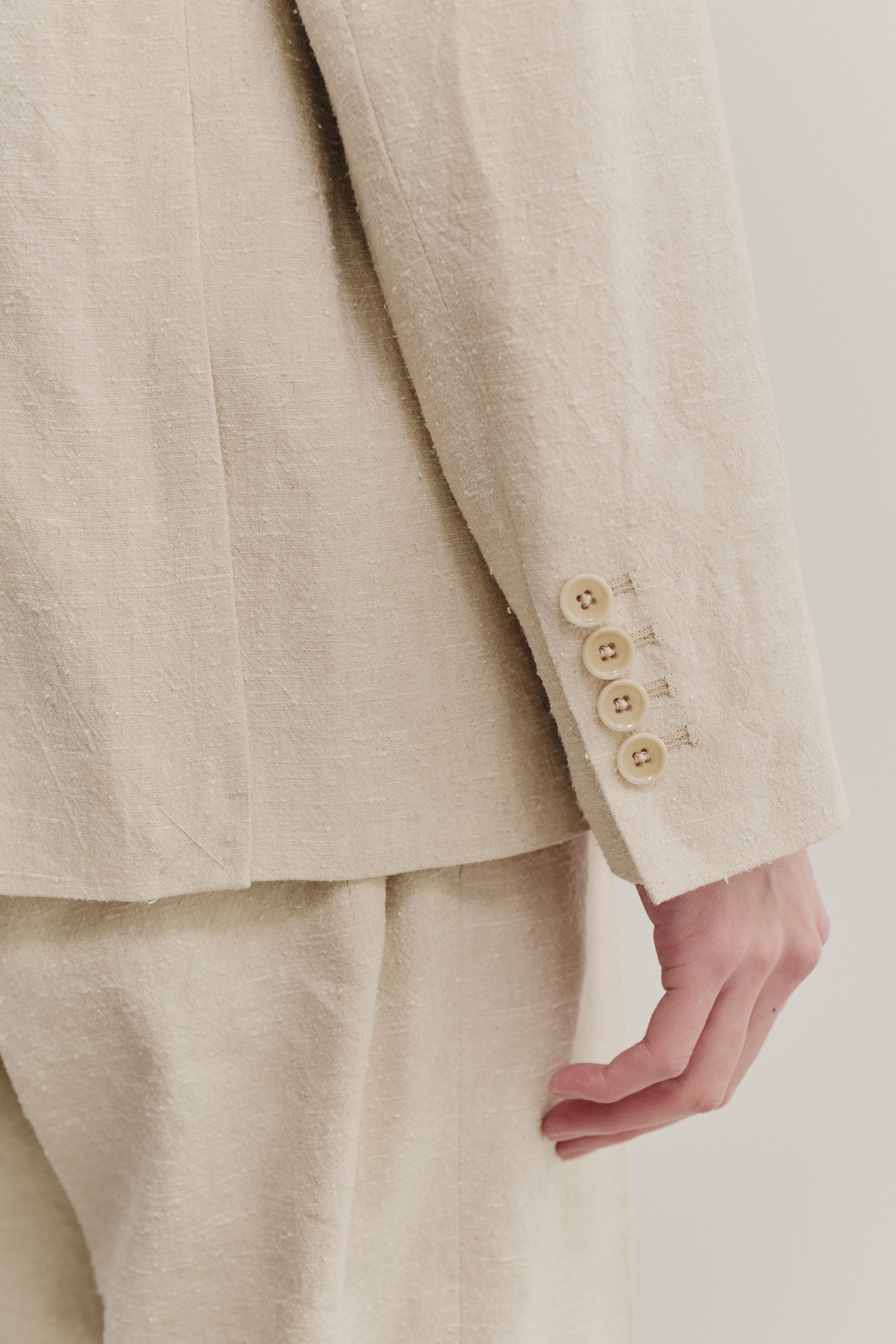 Men's tailoring blazer, linen-silk blend, naturally textured, undyed beige, with four light buttons on the sleeve.