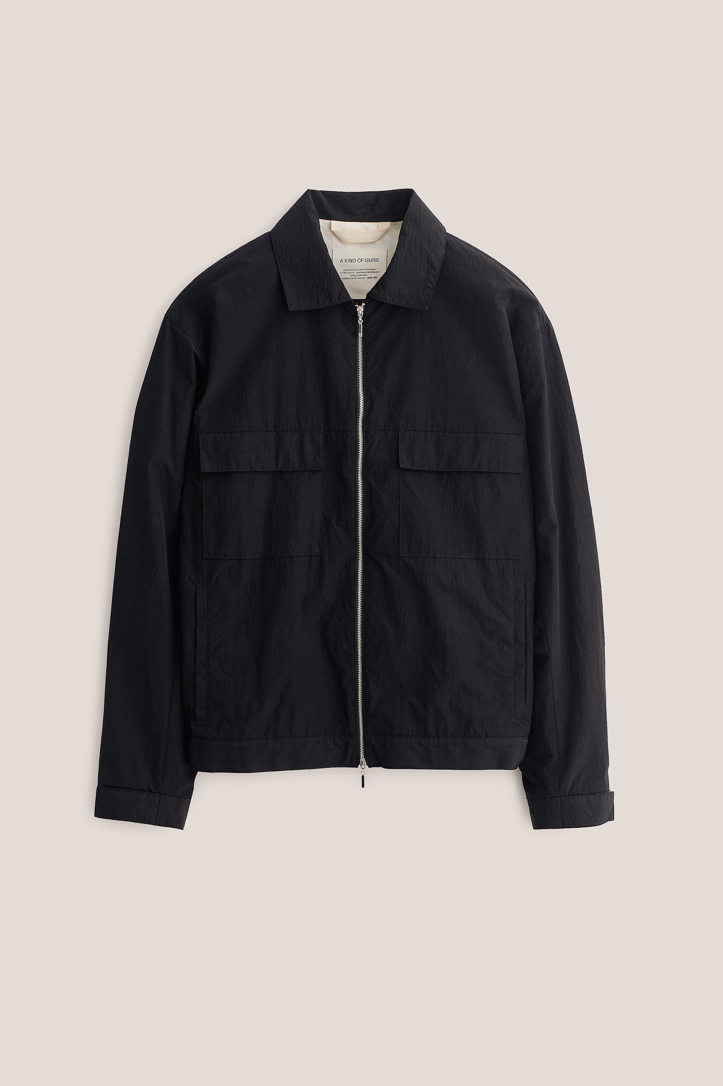Men's outerwear jacket, black recycled nylon-cotton blend, with flap chest pockets and front zip closure.