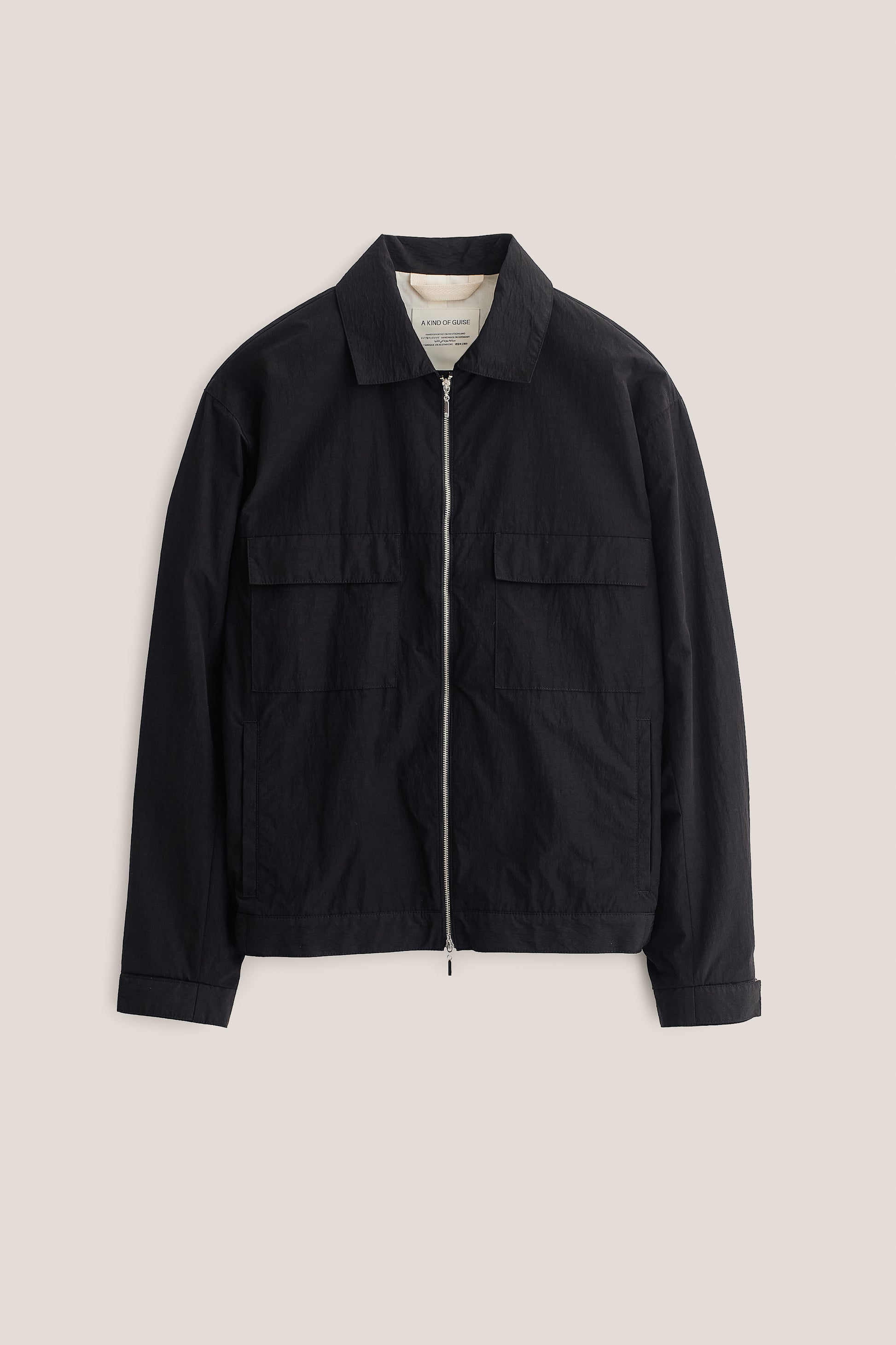 Men's outerwear jacket, black recycled nylon-cotton blend, with flap chest pockets and front zip closure.
