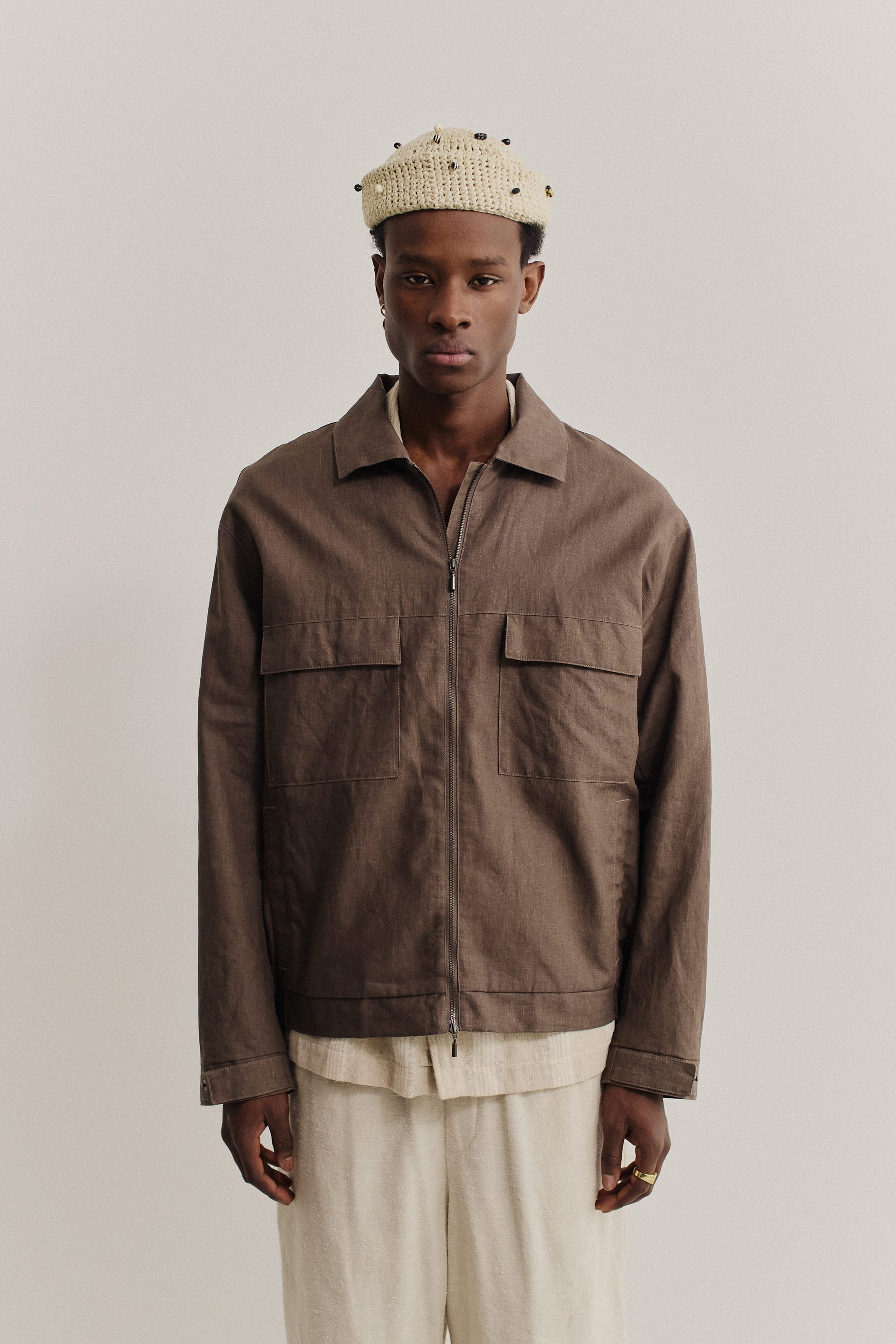 Men's outerwear jacket, 100% linen, natural brown, with flap chest pockets and front zip closure.