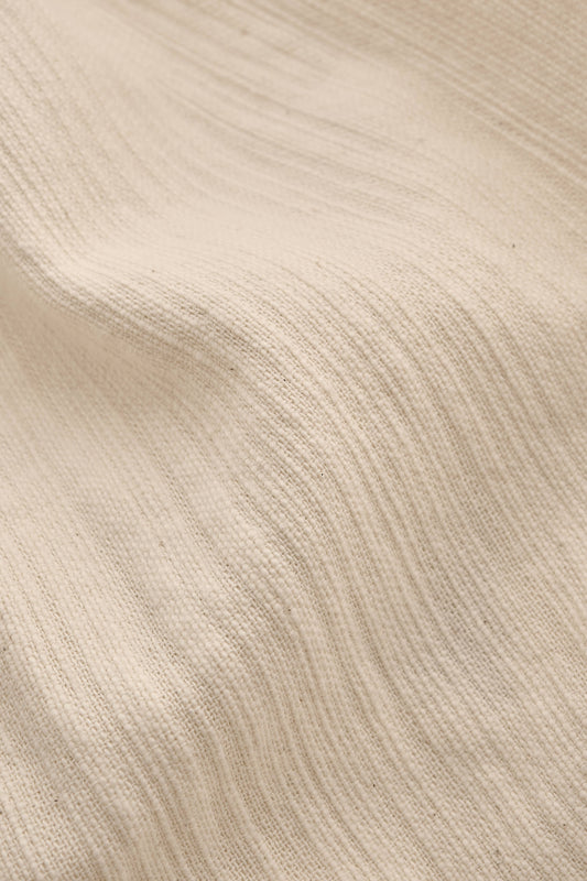 Men's long-sleeved shirt, recycled cotton mix with textured weave, natural slubbed effect, in a light beige color.