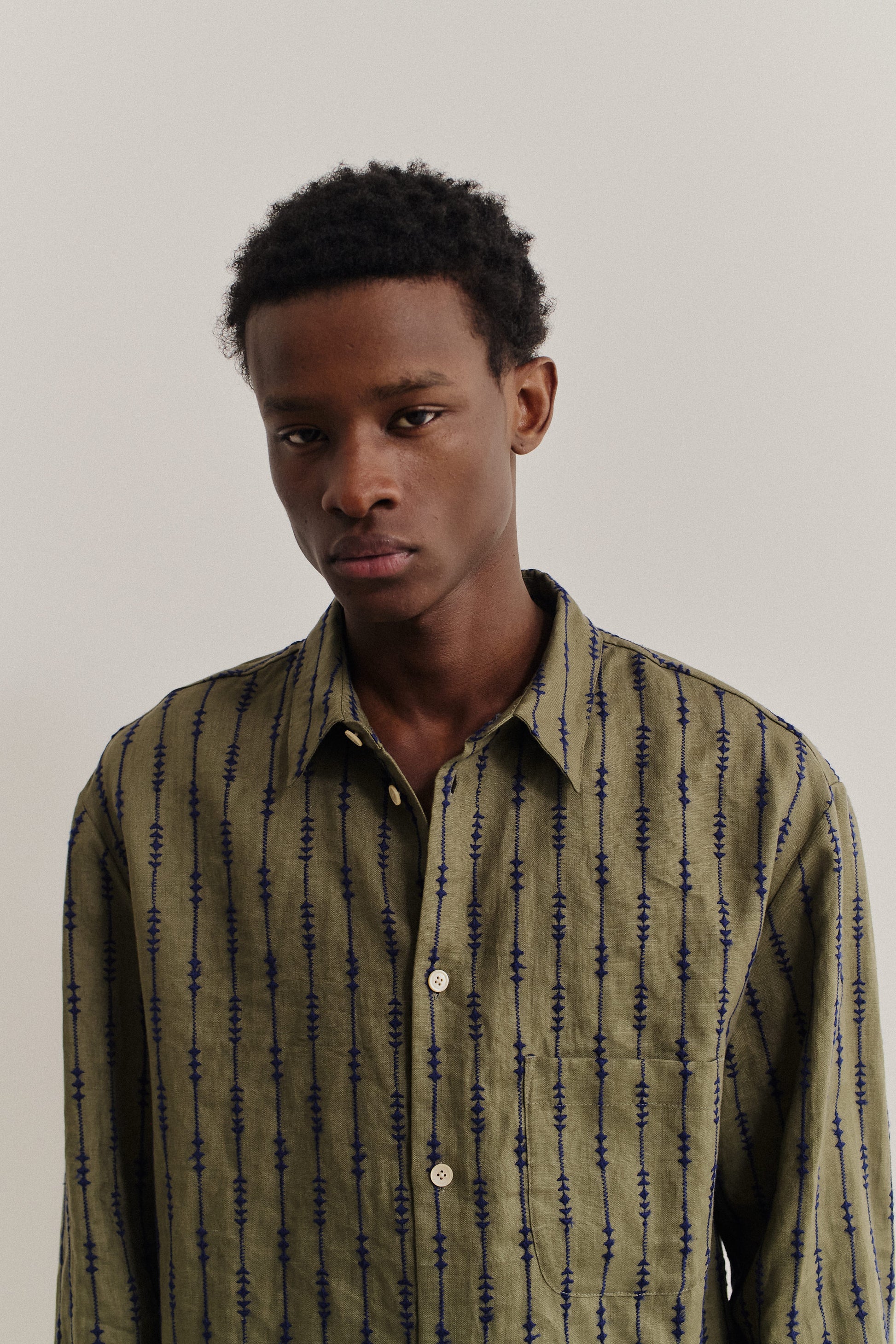 Men's long-sleeved shirt, linen, embroidered, olive green with navy pattern.