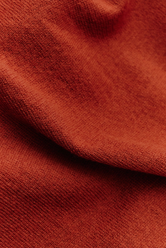 Women's knit cardigan, 100% merino wool, rust, with subtle texture and ribbed trim.