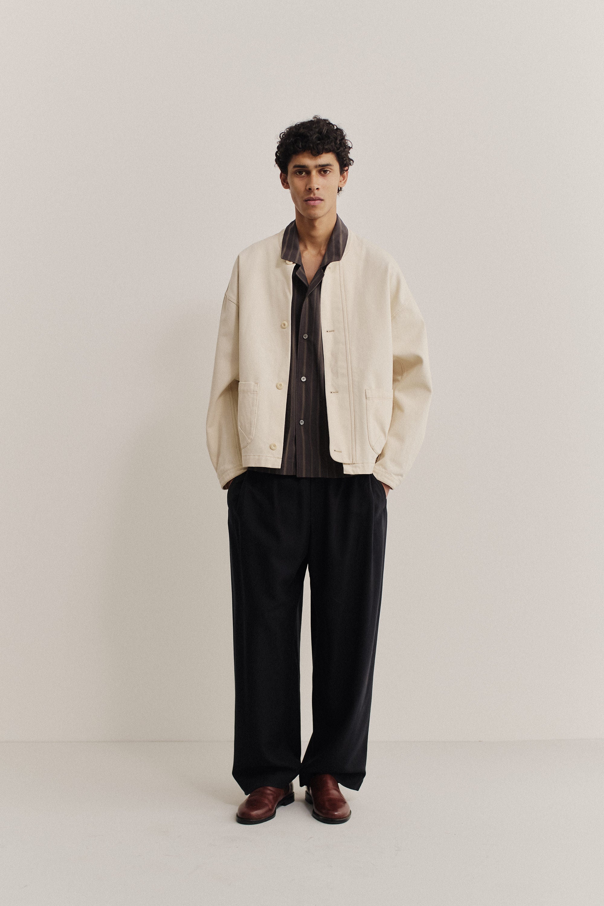 Men's outerwear jacket, organic cotton raw denim, off-white, boxy fit, stand-up collar, patch pockets.