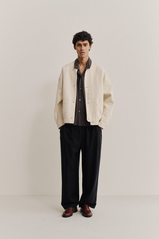 Men's outerwear jacket, organic cotton raw denim, off-white, boxy fit, stand-up collar, patch pockets.