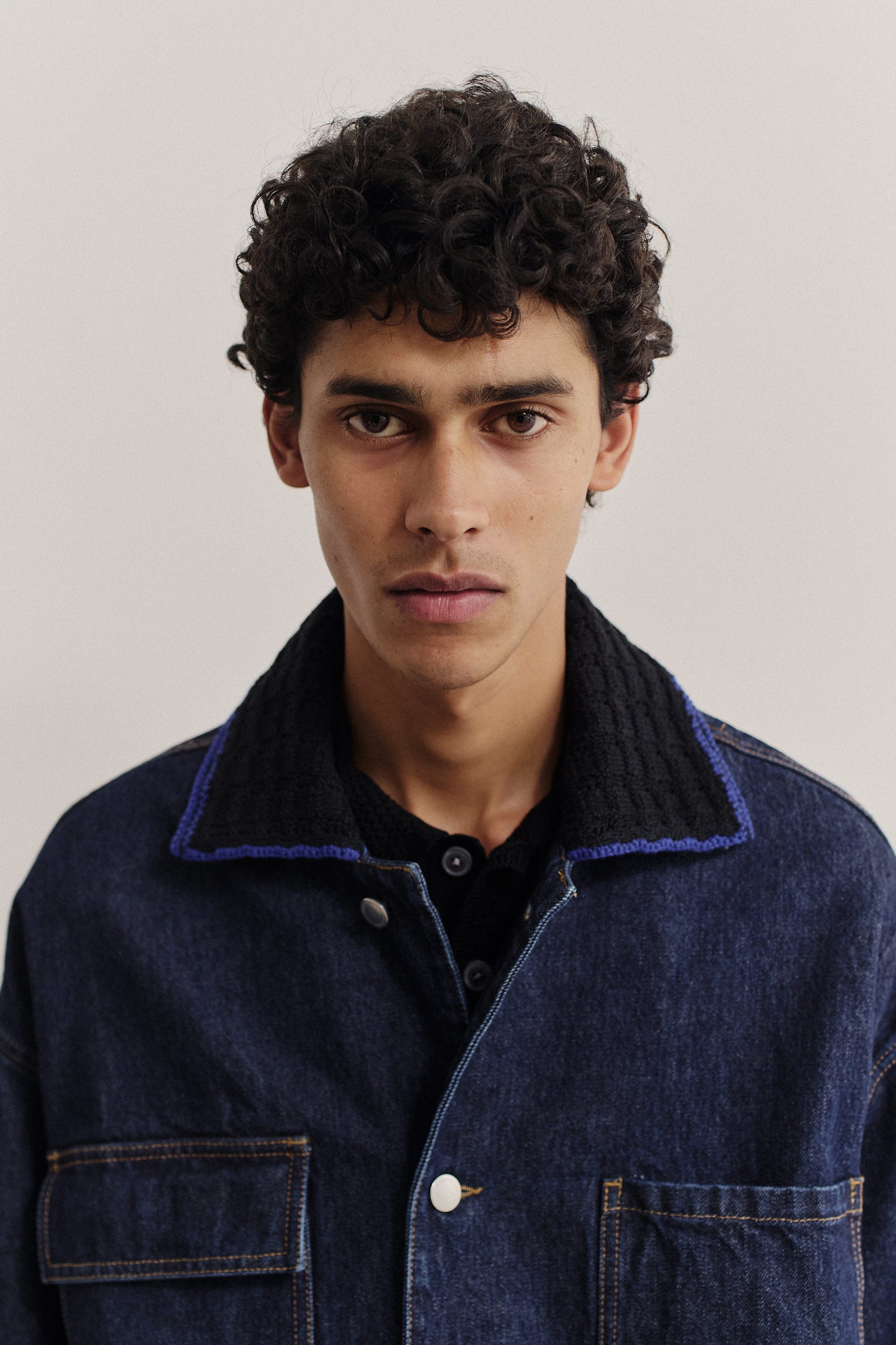 Men's outerwear denim jacket, oversized fit, vintage blue, knitted collar, buttoned front, and patched pockets.