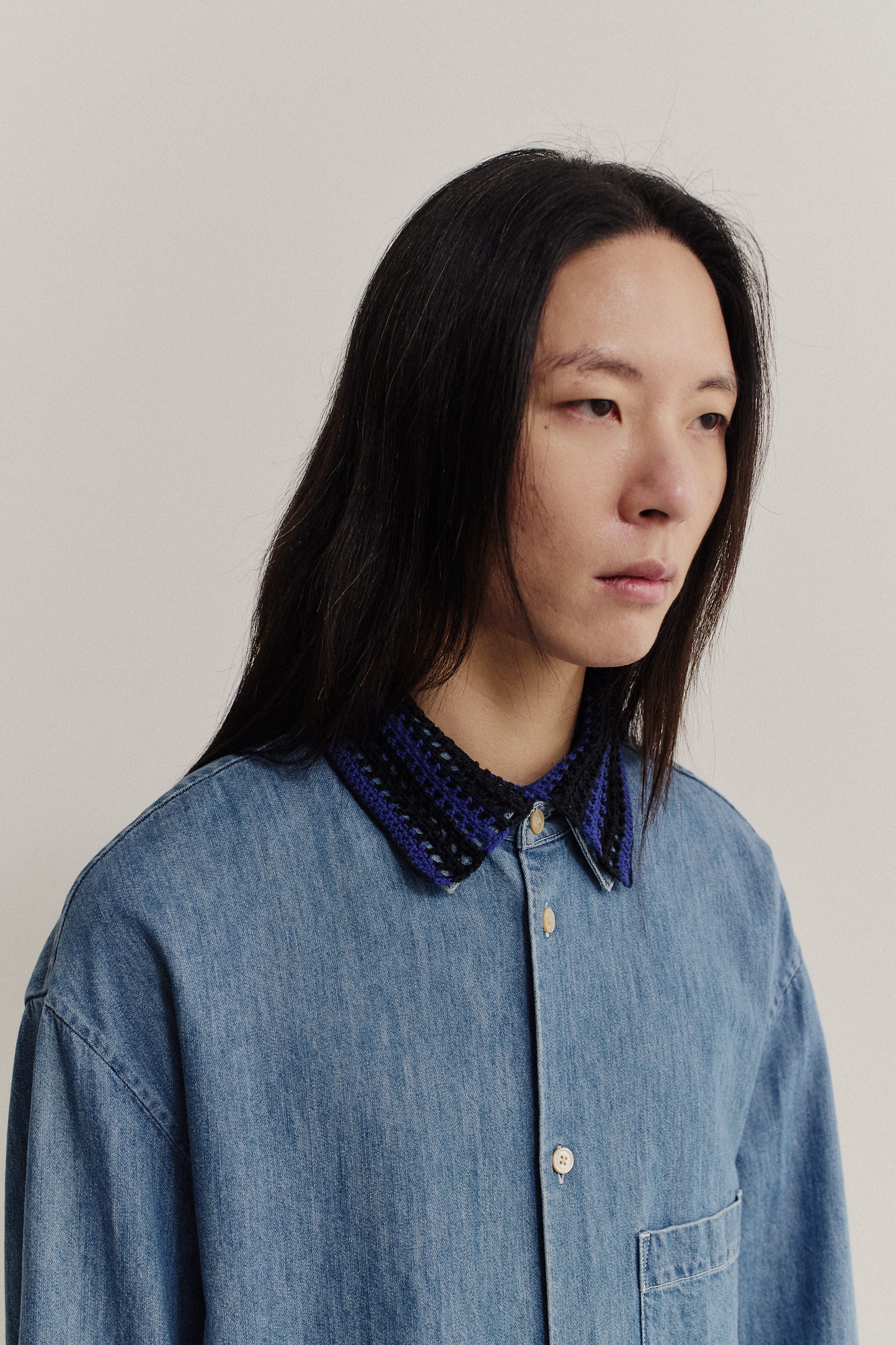 Women's accessories, hand-crocheted Kikoy Collar in black and purple merino wool, worn over a denim shirt.