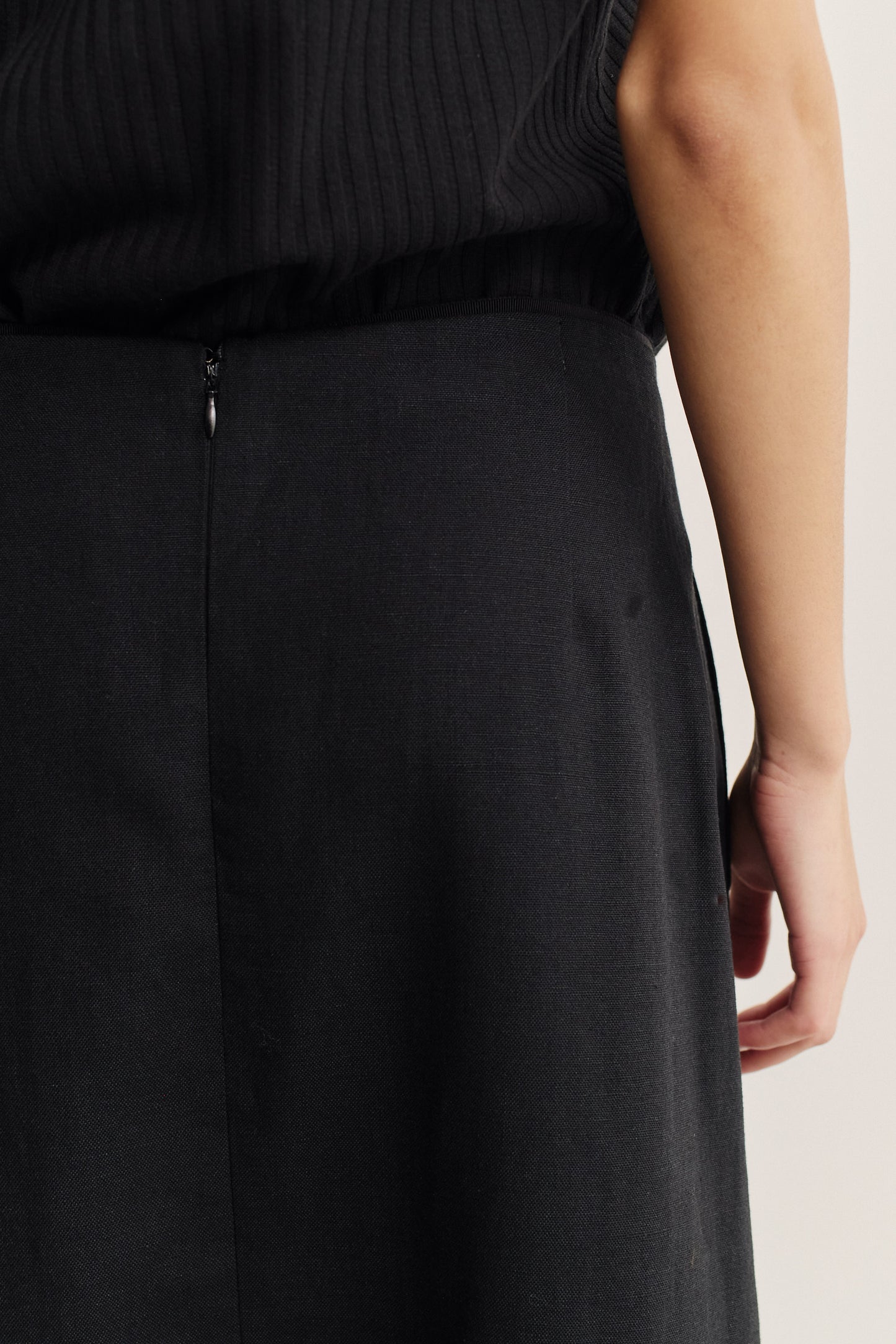 Women's skirt, midi-length, black worsted wool and linen blend, with a back zipper and side pockets.