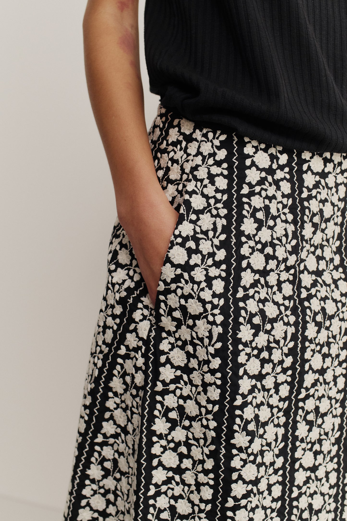 Women's skirt, midi-length, 100% cotton, black with white embroidered floral blocks, o-shaped fit, side pockets.