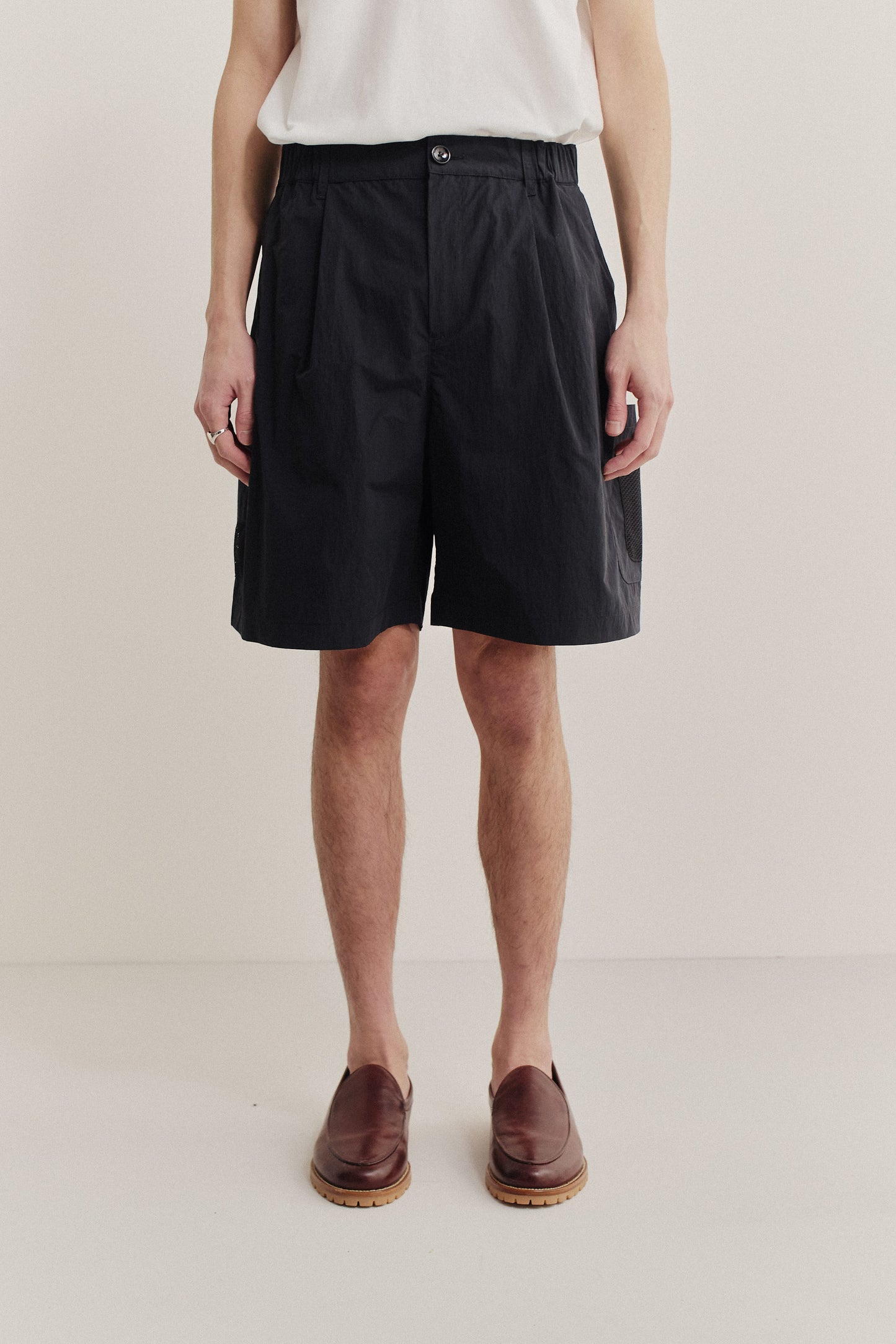 Men's shorts, black recycled nylon cotton blend, relaxed fit with front pleats and side patch pockets.