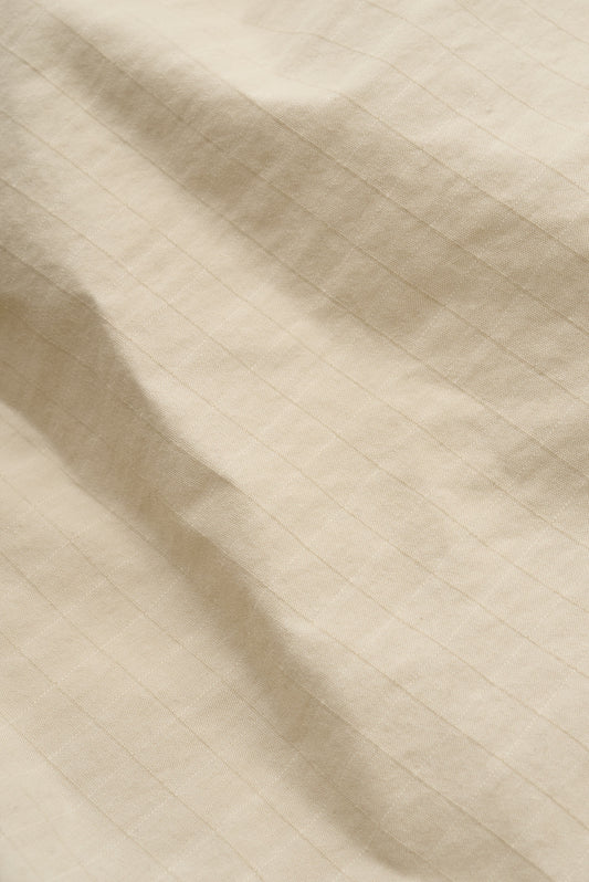 Men's shorts, cotton blend ripstop, waxed finish, beige, with subtle striped texture.