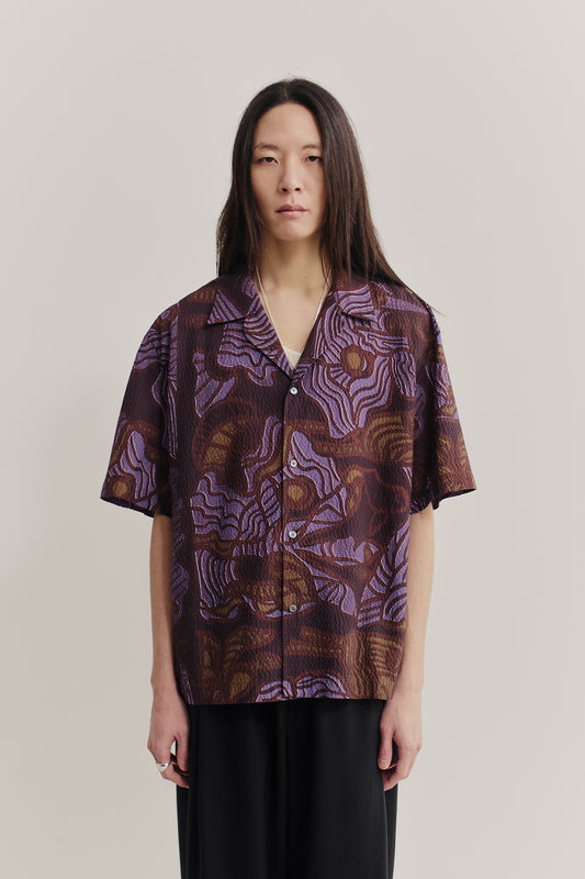 Men's short-sleeved shirt, cotton seersucker, brown with purple African wildlife print, notched collar.