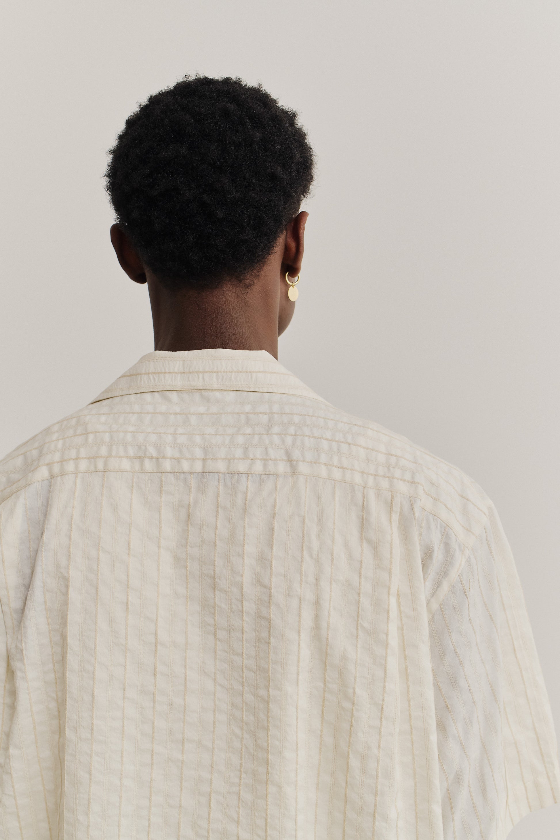 Men's short-sleeved shirt, washed cotton-silk-linen blend, cream with subtle striped texture.
