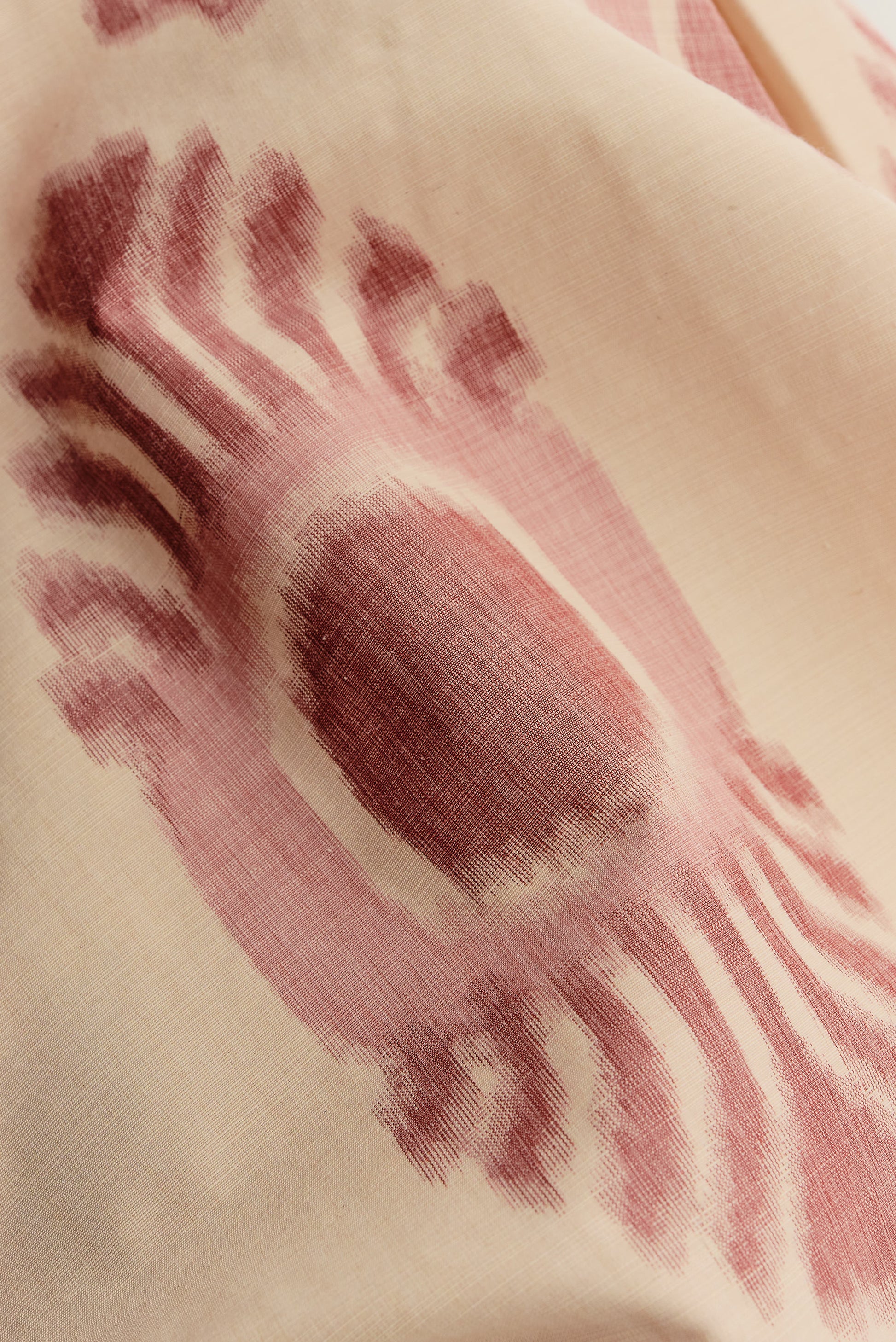 Men's long-pants, cotton and recycled polyester blend, ikat print, off-white with burgundy pattern.