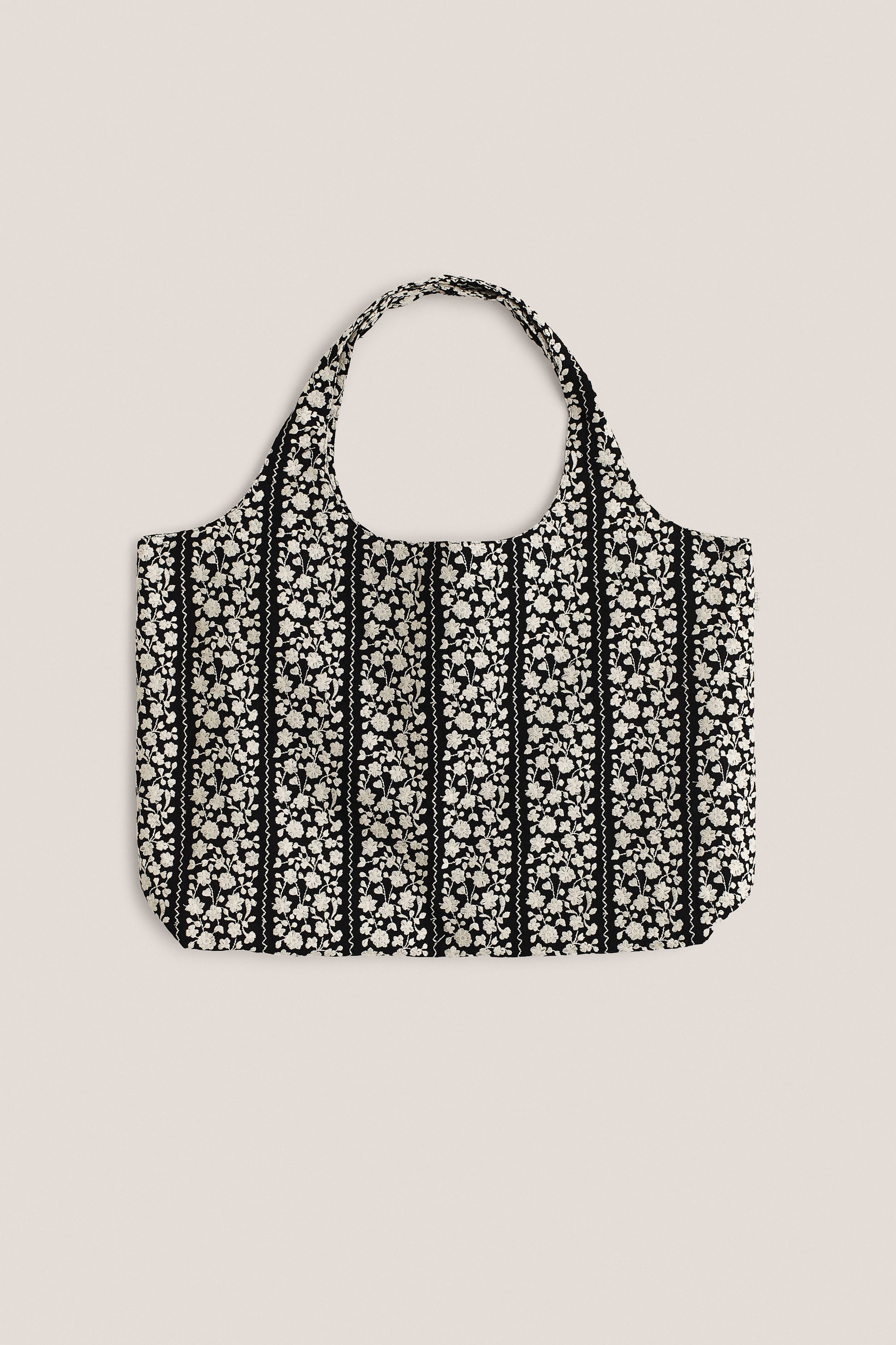 Women's accessories bag, 100% cotton, black with embroidered white flower blocks and wavy lines.
