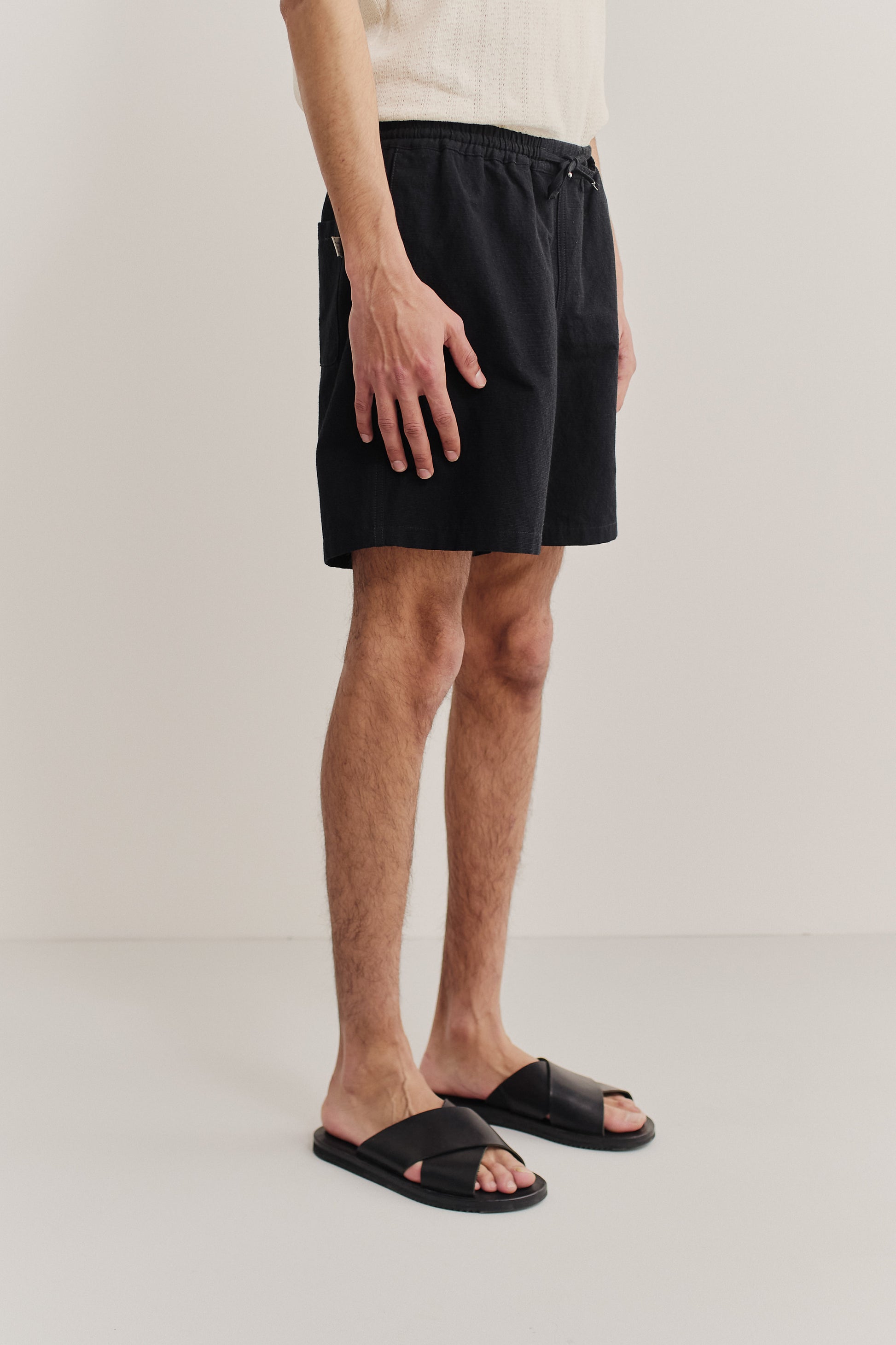 Men's shorts, worsted wool and linen blend, black, with adjustable waistband and side pockets.