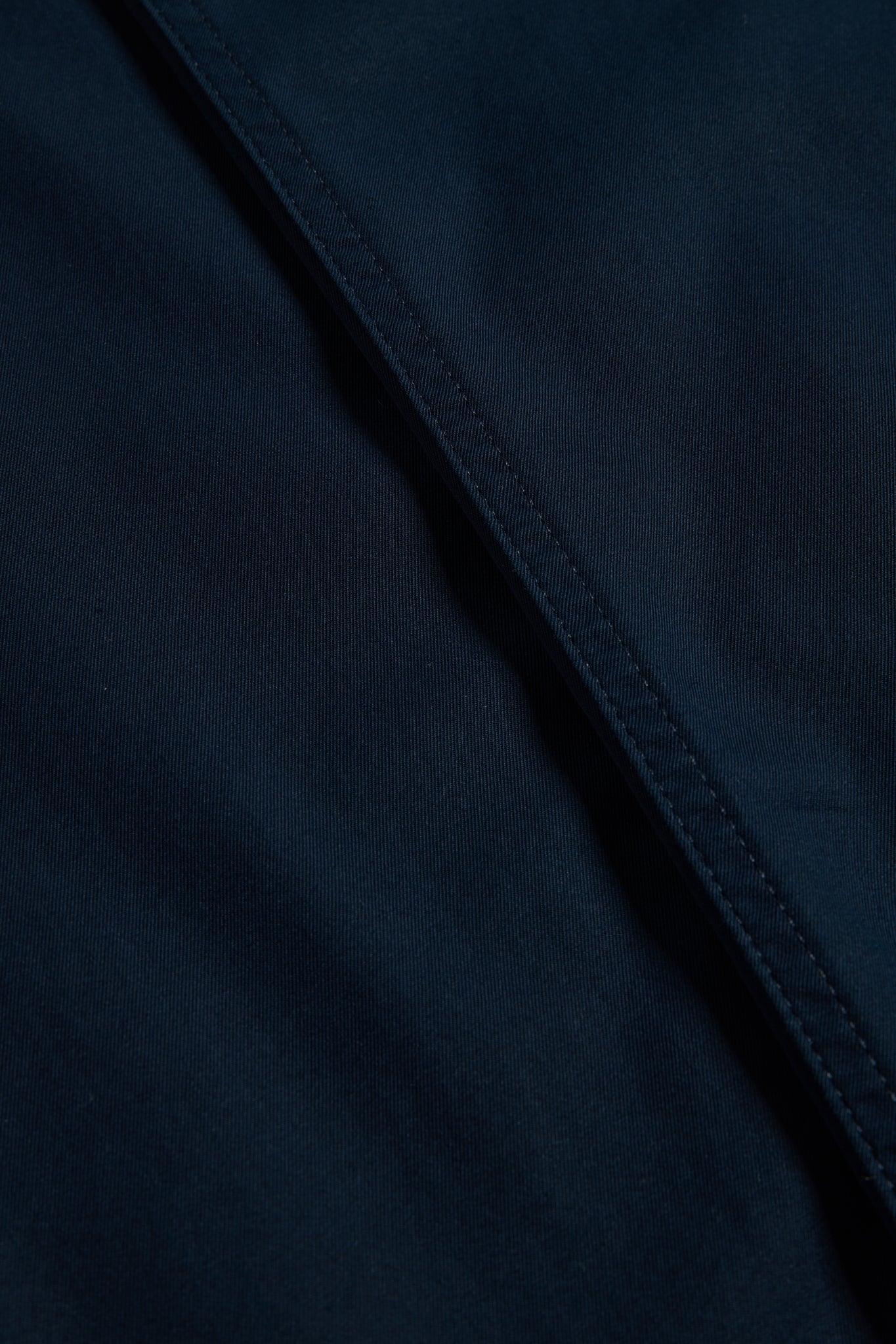 Men's long-pants, organic cotton twill, washed navy, with visible stitching detail.