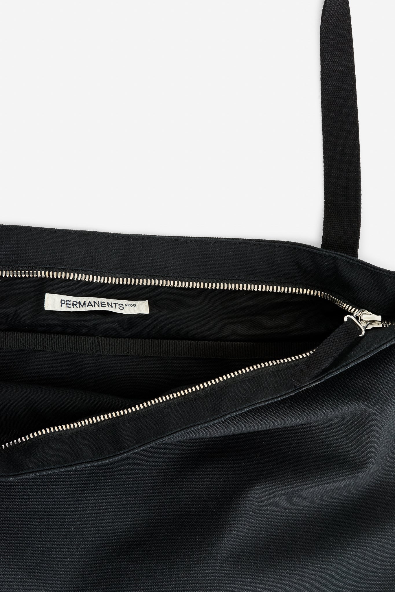 Unisex accessories tote bag, recycled cotton, water-repellent, black, with silver zipper and "PERMANENTS" label.